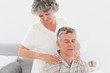 Retired woman giving a massage to her husband at home Retired woman giving a massage to her husband at home