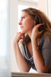 Sad beautiful woman against a window