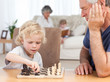 Young boy playing chess with his grandfather