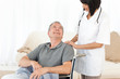 Man in his wheelchair with his nurse at home Man in his wheelchair with his nurse at home