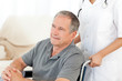 Man in his wheelchair with his nurse at home Man in his wheelchair with his nurse at home