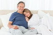 Photo: Senior couple lying down on their bed Senior couple lying down on their bed