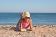 Girl child reads a book at the beach Girl child reads a book at the beach