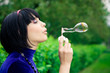 young female makes soap bubbles