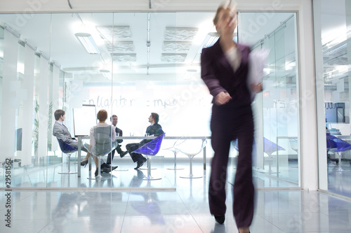 Photo: Businesswoman walking away from conference room Businesswoman walking away from conference room