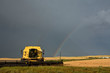 Rainbow behind parked combine in Saskatchewan