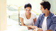 Smiling young couple sitting together and working on a laptop