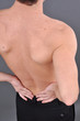 young caucasian man with pain in a back isolated on white