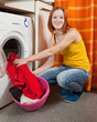 woman putting clothes into washing machine