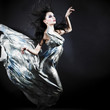 Dancing sexy young woman with flying hair and silk dress