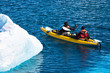 Two men in a canoe among icebergs in Antarctica