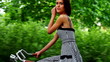Beautiful young woman riding a bicycle in countryside