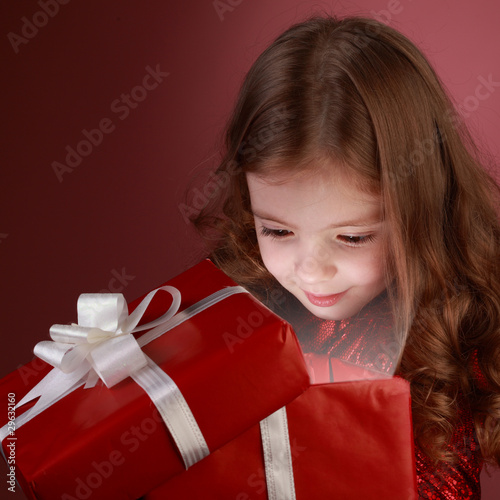Photo: litle girl open red gift box litle girl open red gift box