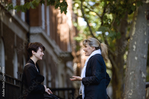 Photo: Two mothers pushing their buggies, talking Two mothers pushing their buggies, talking