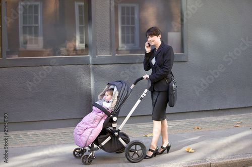 Photo: A mother pushing a buggy, talking on her mobile phone A mother pushing a buggy, talking on her mobile phone