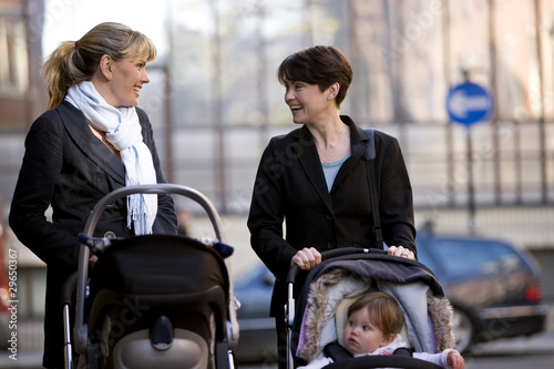 Photo: Two mothers pushing their buggies in the street Two mothers pushing their buggies in the street