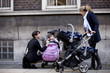 Two mothers with buggies meeting in the street