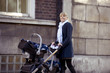 A mother pushing a double buggy in the street