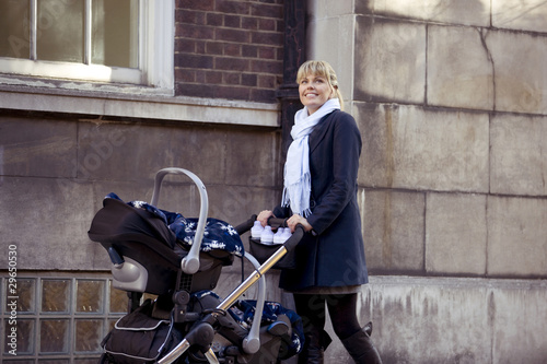 Photo: A mother pushing a double buggy in the street A mother pushing a double buggy in the street
