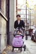 A mother pushing a buggy in the street