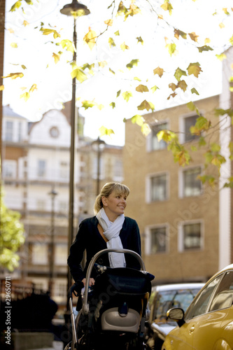 Photo: A mother pushing a buggy in the street A mother pushing a buggy in the street