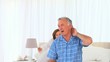 Senior woman massaging her husbands neck in the bedroom