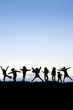 Silhhouette of group of kids playing around and jumping