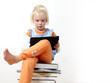 Cute blond child is reading on touchpad