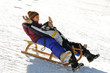 Brother and sister sledding down the hill, snow, winter Brother and sister sledding down the hill, snow, winter