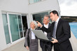 Senior couple visiting luxury villa with real-estate agent