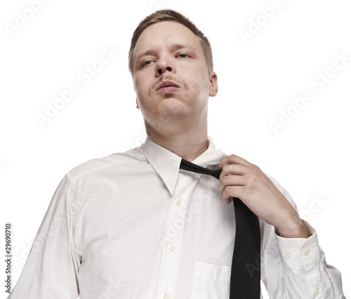 Foto: A tired white collar worker loosening his tie. A tired white collar worker loosening his tie.