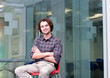 Smiling man sitting on chair in office