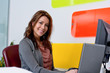 Smiling young woman at desk in office