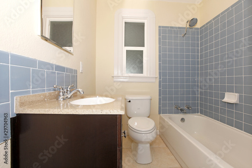 Photo: Blue tiles in bathroom with dark cabinet and yellow walls Blue tiles in bathroom with dark cabinet and yellow walls