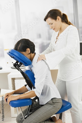 Photo: Businesswoman getting neck massage Businesswoman getting neck massage