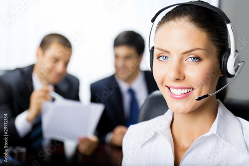 Foto: Portrait of happy smiling upport phone operator at workplace Portrait of happy smiling upport phone operator at workplace