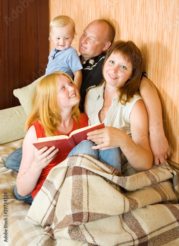 Photo: family sitting on couch and reading family sitting on couch and reading