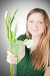Young blonde girl with tulips, with grey background Young blonde girl with tulips, with grey background