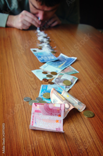 Photo: The best drugs is money. Young man snorting drugs made from mone The best drugs is money. Young man snorting drugs made from mone