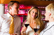 Mann und zwei Frauen in einer Hotelbar