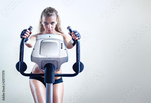 Photo: Young woman on exercise bicycle Young woman on exercise bicycle
