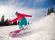 Snowboarder jumping through air with  blue sky in background