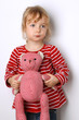 Kleines Kind kuschelt mit Teddy