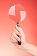 Magnifying glass in woman hand  on red background