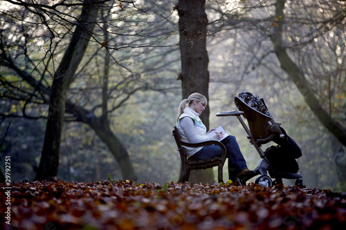 Photo: A young mother sitting on a bench, writing in a journal A young mother sitting on a bench, writing in a journal