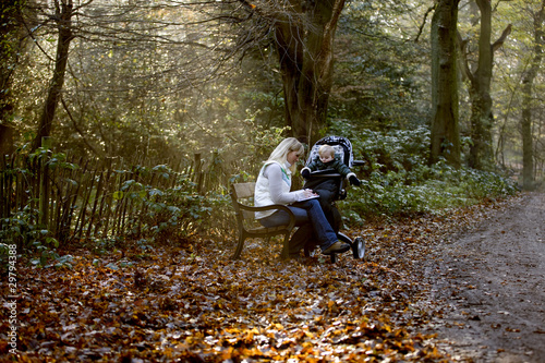 Photo: A young mother sitting on a bench, writing in a journal A young mother sitting on a bench, writing in a journal