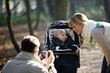 A father photographing his partner and child in the park