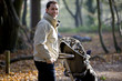 A young father pushing a stroller in the park