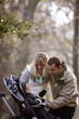 A young couple smiling at their son in a stroller