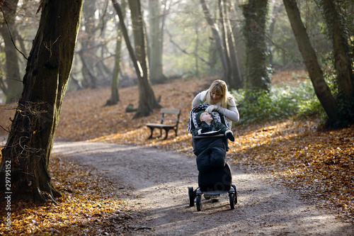 Photo: A young mother checking on her son in a stroller A young mother checking on her son in a stroller